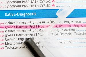 ein Ausschnitt eines Laboruntersuchungsformulares, mit den Parametern der Hormone. oberdrauf liegt das Abnahmeröhrchen. Hormone im Speichel bestimmen in Seligenstadt. Dagmar Klein
